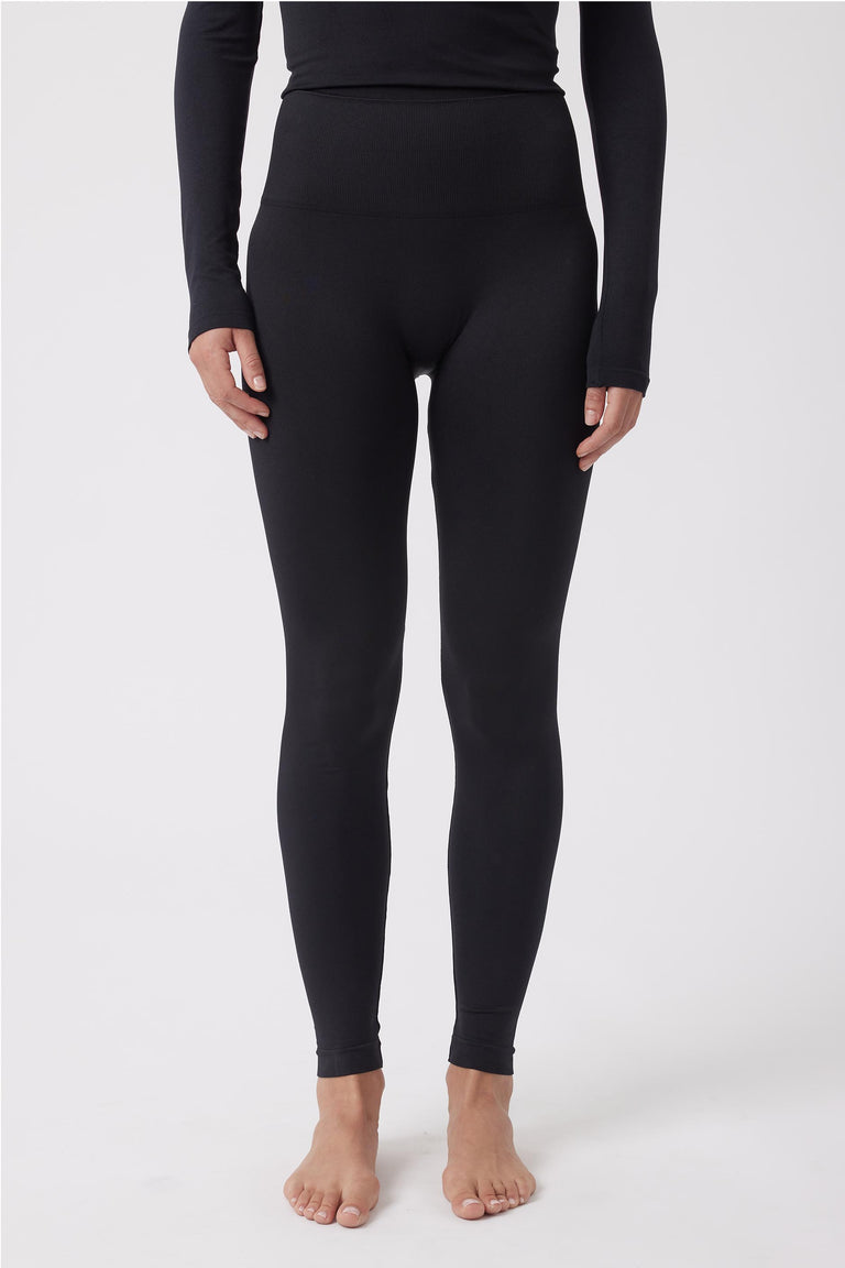 Front view of a person wearing black seamless high-waisted leggings paired with a fitted long-sleeve black top.