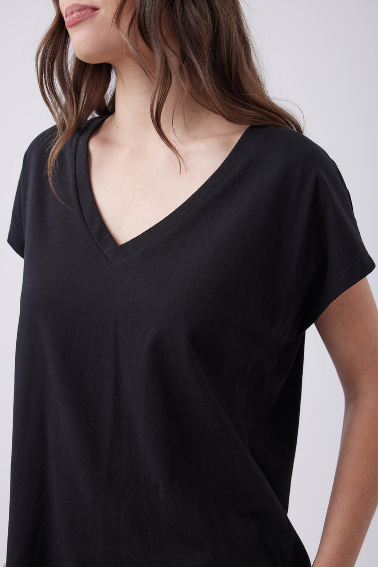 Woman wearing a soft black V-neck tee with short sleeves, designed for effortless everyday comfort and style