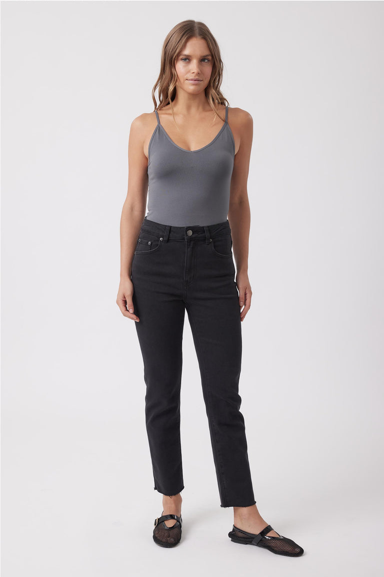 Woman wearing a grey fitted V neck tank top with black jeans and sandals