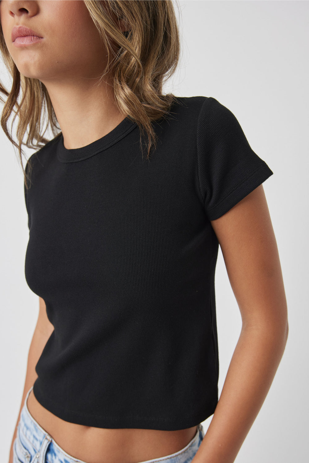 Girl wearing Girls Harper Crop Tee in black ribbed fabric styled casually with light denim by DECJUBA Australian fashion brand
