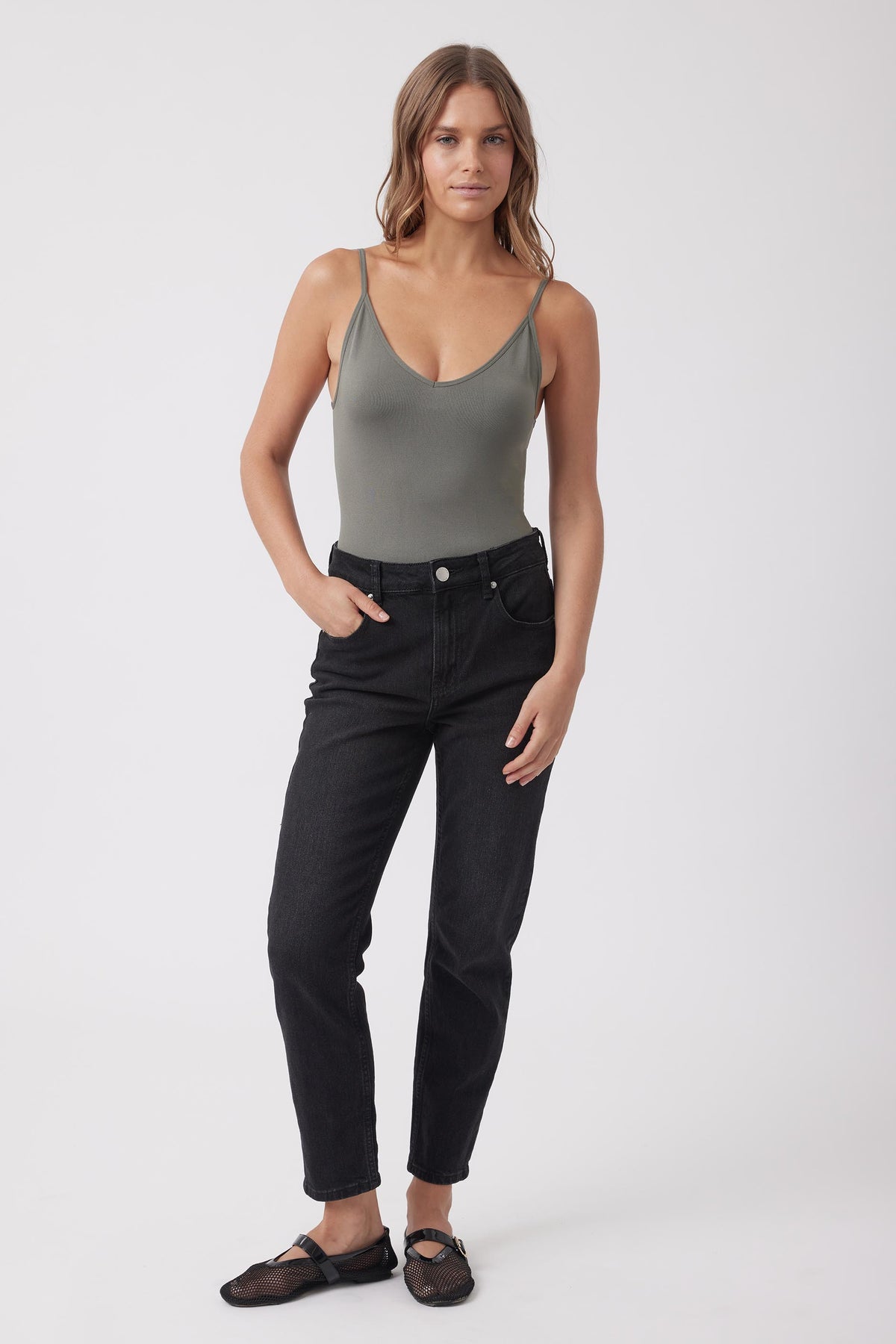 Woman wearing a grey fitted V neck tank top with black jeans