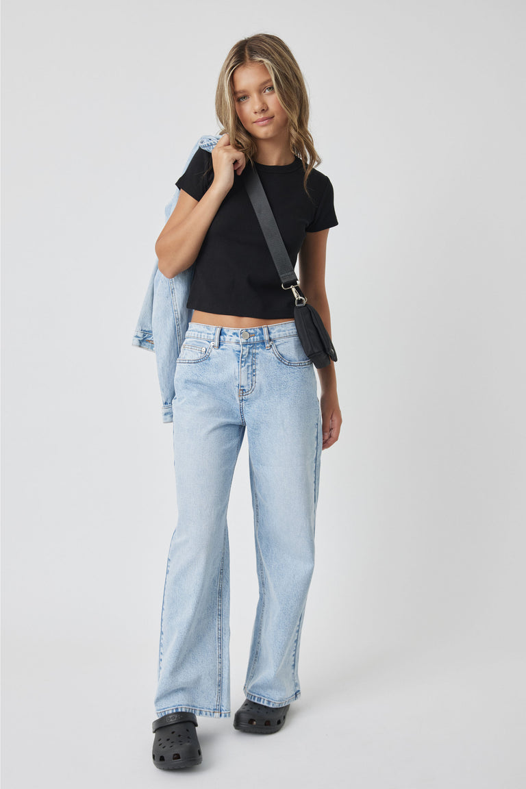Girl wearing Girls Harper Crop Tee in black paired with light wash denim jeans and crossbody bag by DECJUBA Australian fashion brand