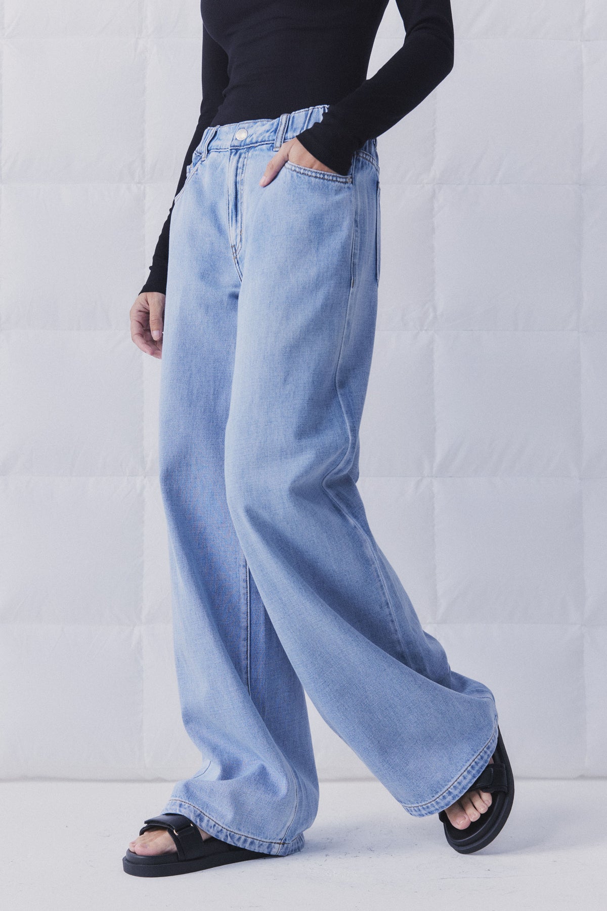 D-Luxe Wide Leg Jean in light denim with elasticated high rise waist, styled casually in portrait gallery image 3.