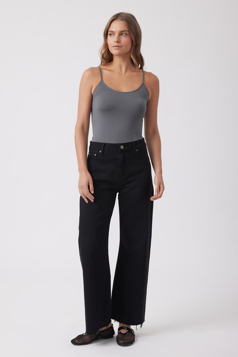 Woman wearing a grey seamless thin strap tank and black wide leg jeans