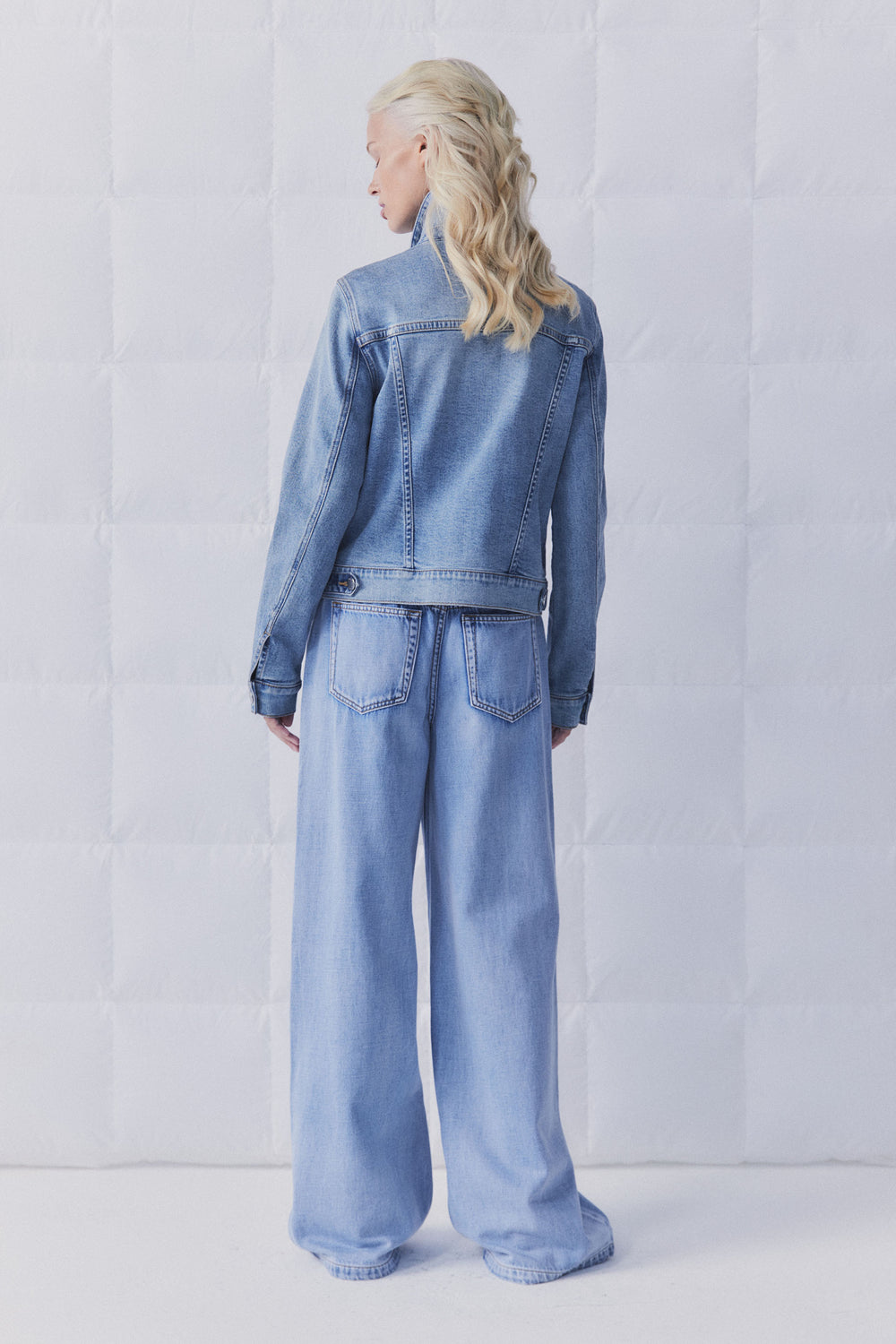 Rear view of model wearing D-Luxe Sienna Denim Jacket in gallery position 4 with light blue wide-leg jeans in portrait format