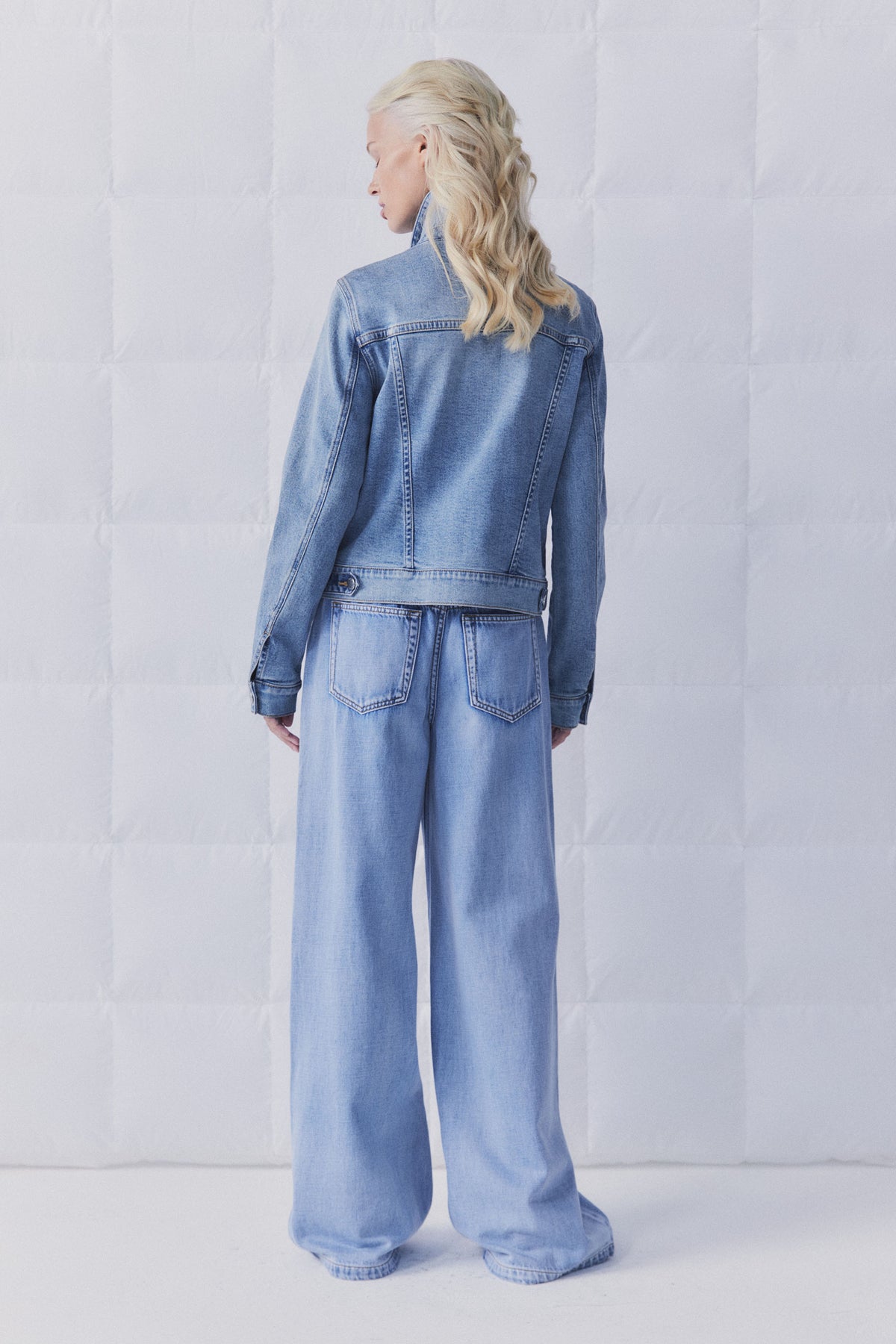 Rear view of model wearing D-Luxe Sienna Denim Jacket in gallery position 4 with light blue wide-leg jeans in portrait format