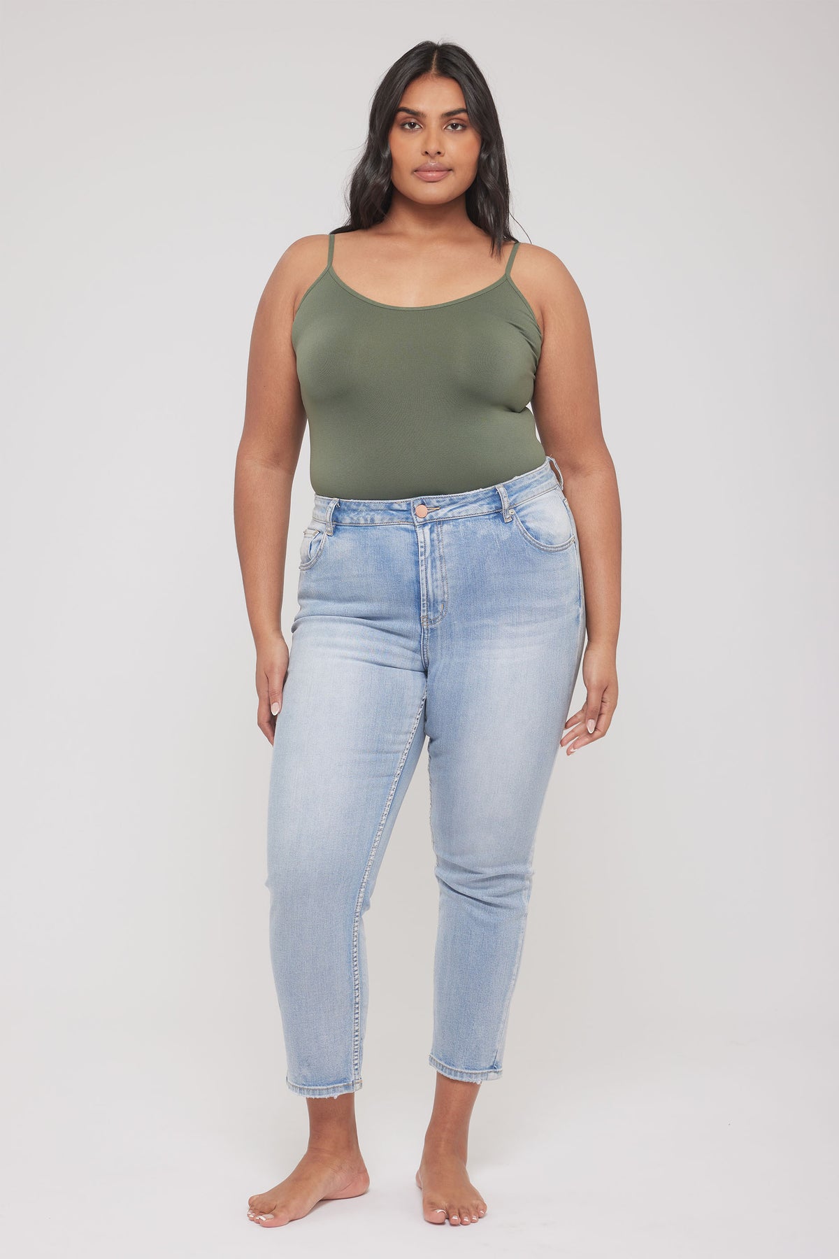 Model wearing an olive green thin strap tank top with light wash high waisted jeans