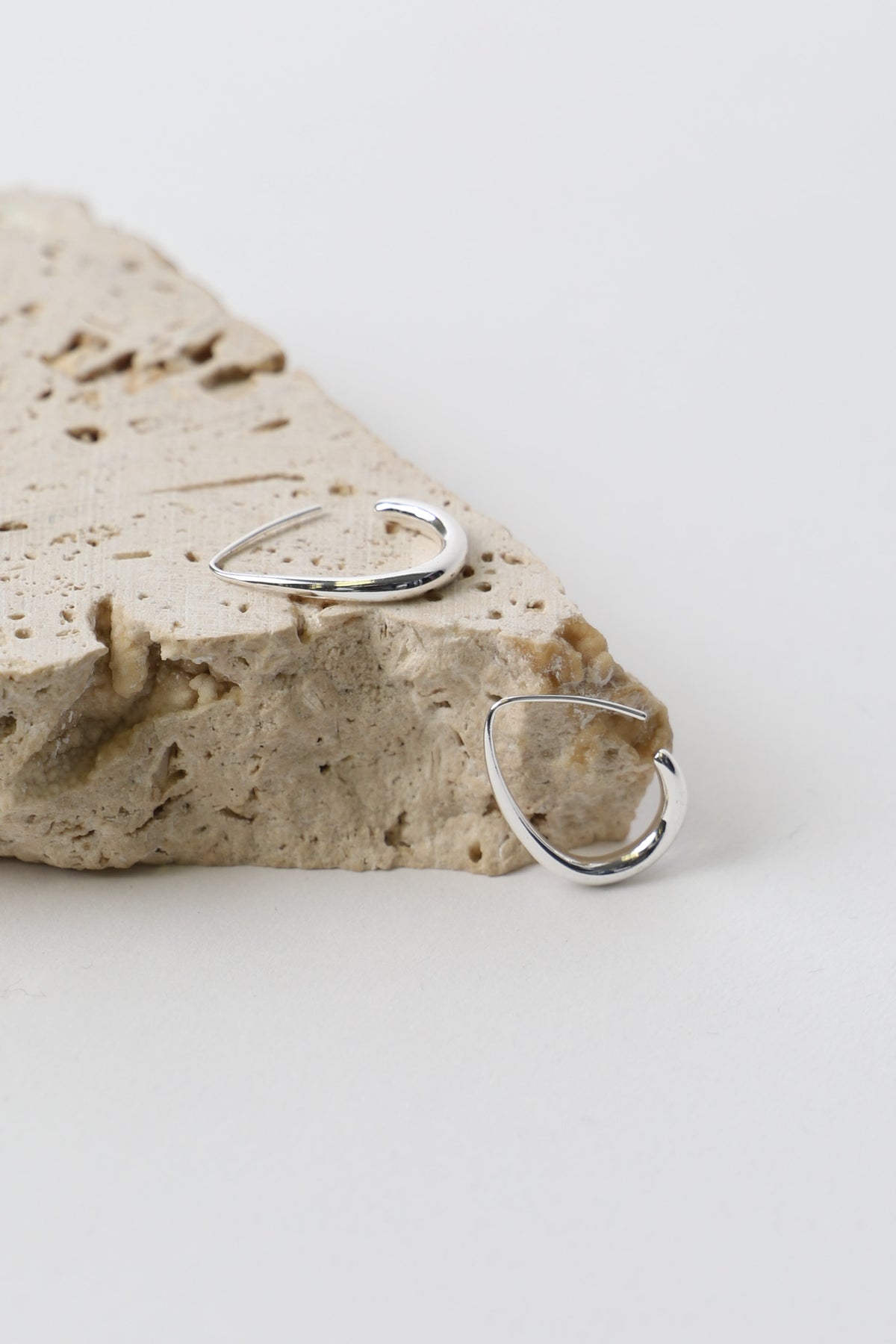 9ct Minimalist Hoop Earrings resting on textured stone, gallery position 4, portrait orientation, 1365x2048 dimensions.