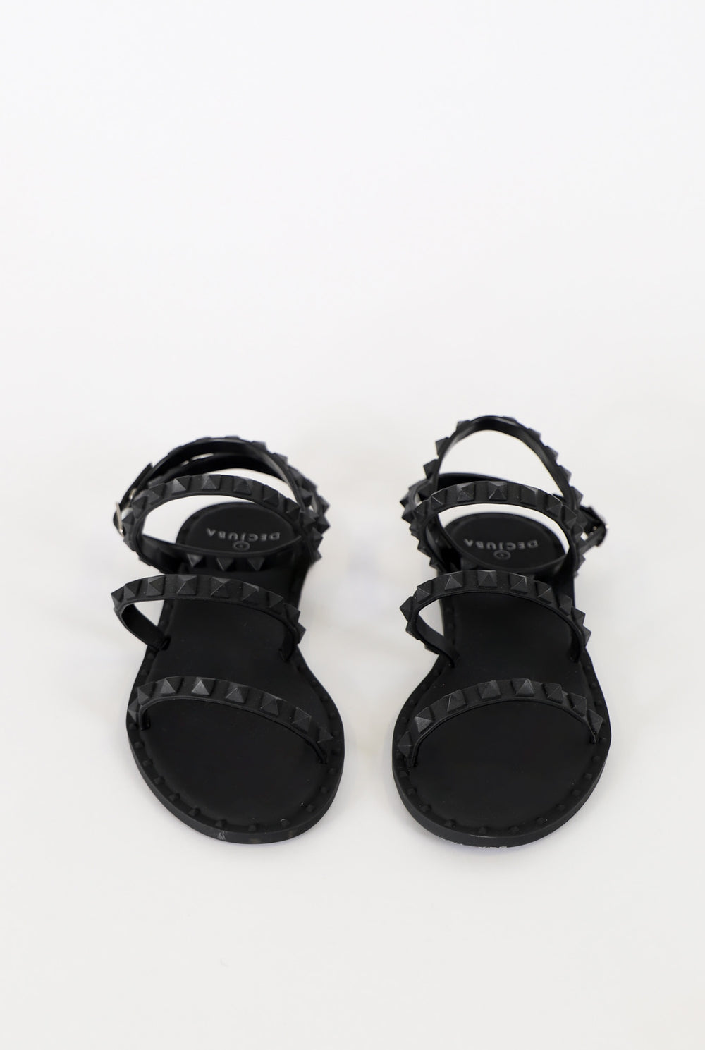 Black strappy sandals with pyramid stud accents and a sleek, minimalist design for stylish everyday wear.