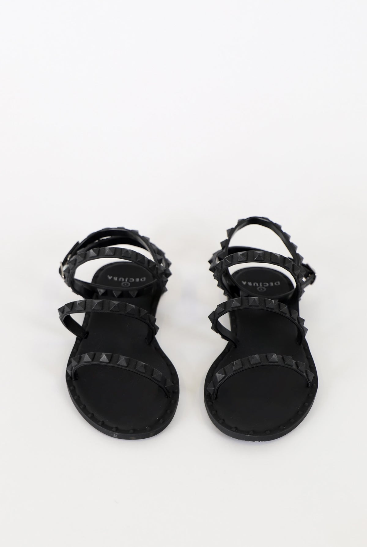 Black strappy sandals with pyramid stud accents and a sleek, minimalist design for stylish everyday wear.
