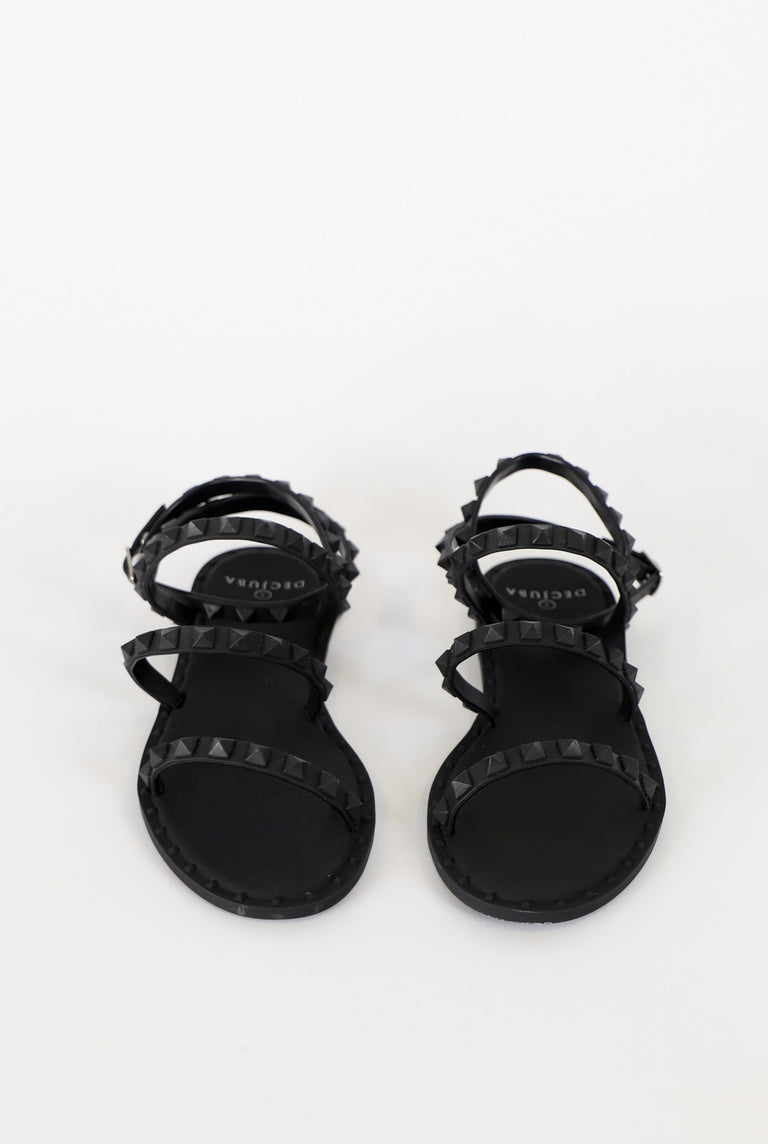 Black strappy sandals with pyramid stud accents and a sleek, minimalist design for stylish everyday wear.