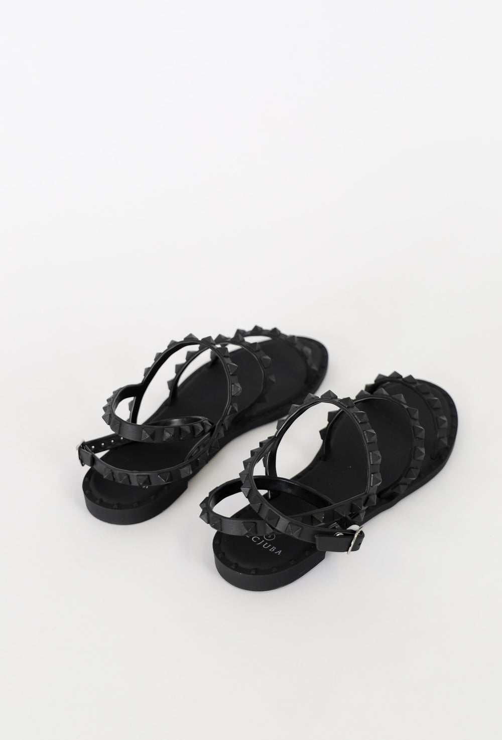 Black strappy flat sandals featuring studded detailing and an adjustable buckle for a chic, everyday look.
