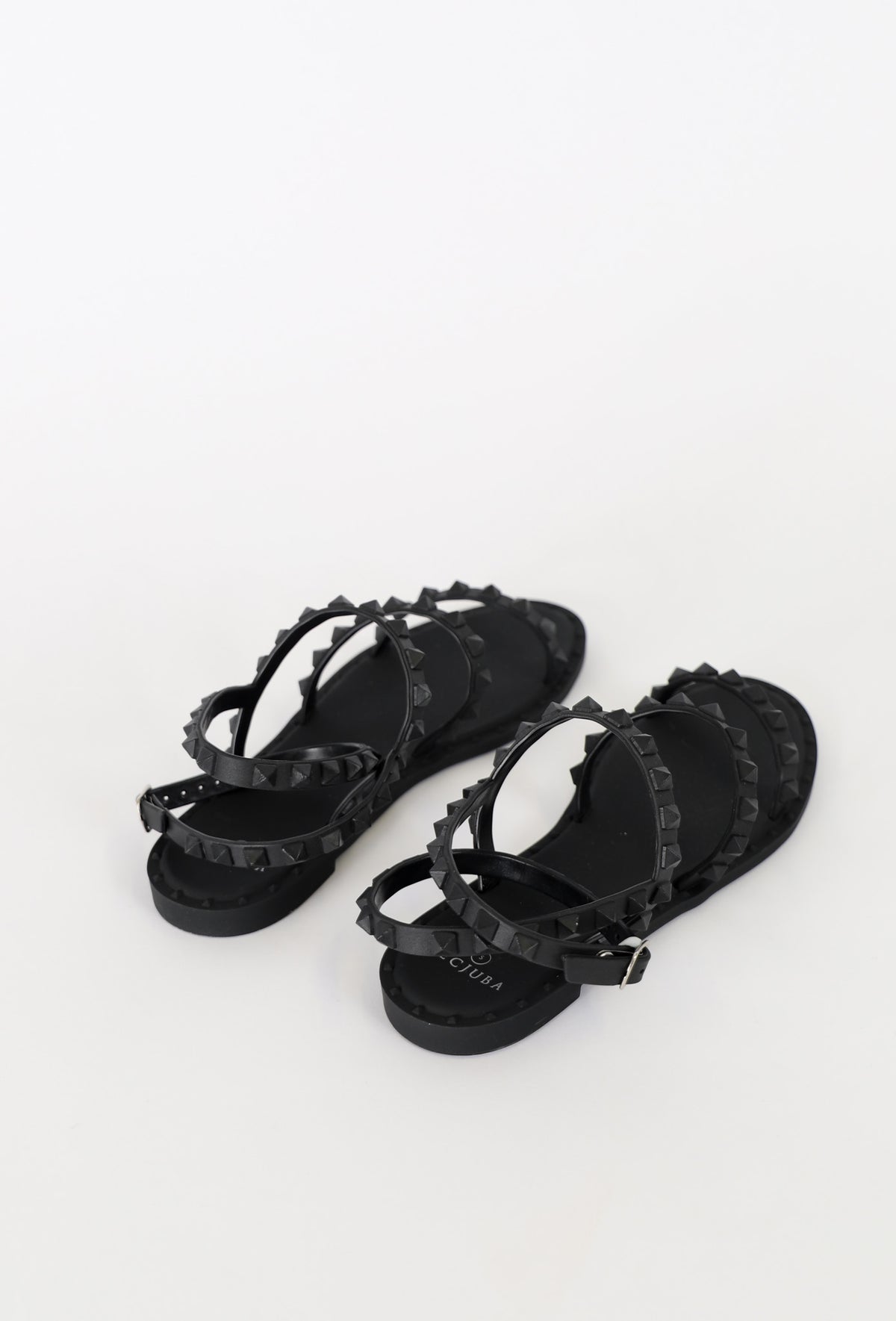 Black strappy flat sandals featuring studded detailing and an adjustable buckle for a chic, everyday look.