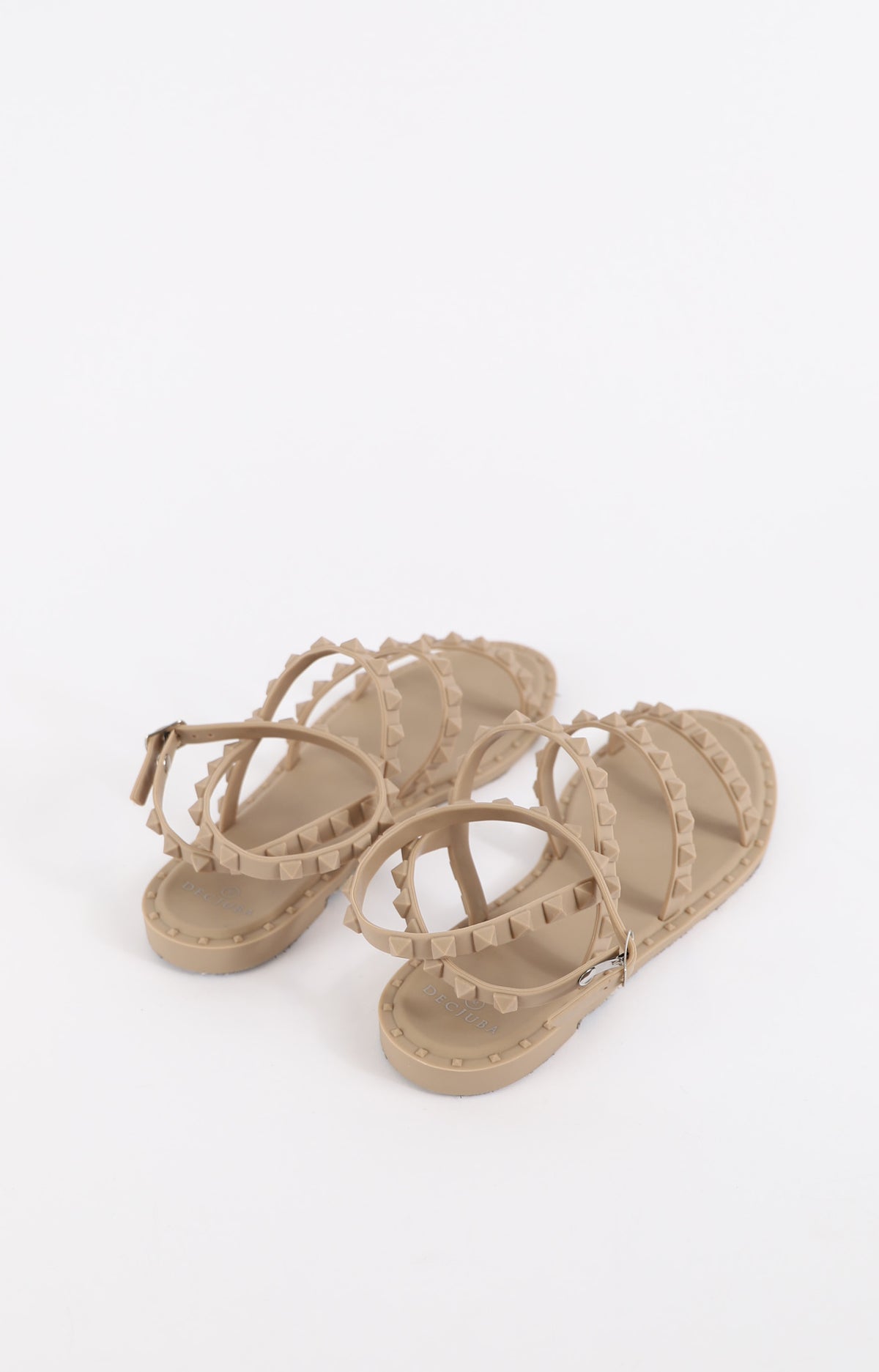 Beige strappy sandals with studded accents and buckle closure, combining casual comfort with edgy style for warm weather wear.