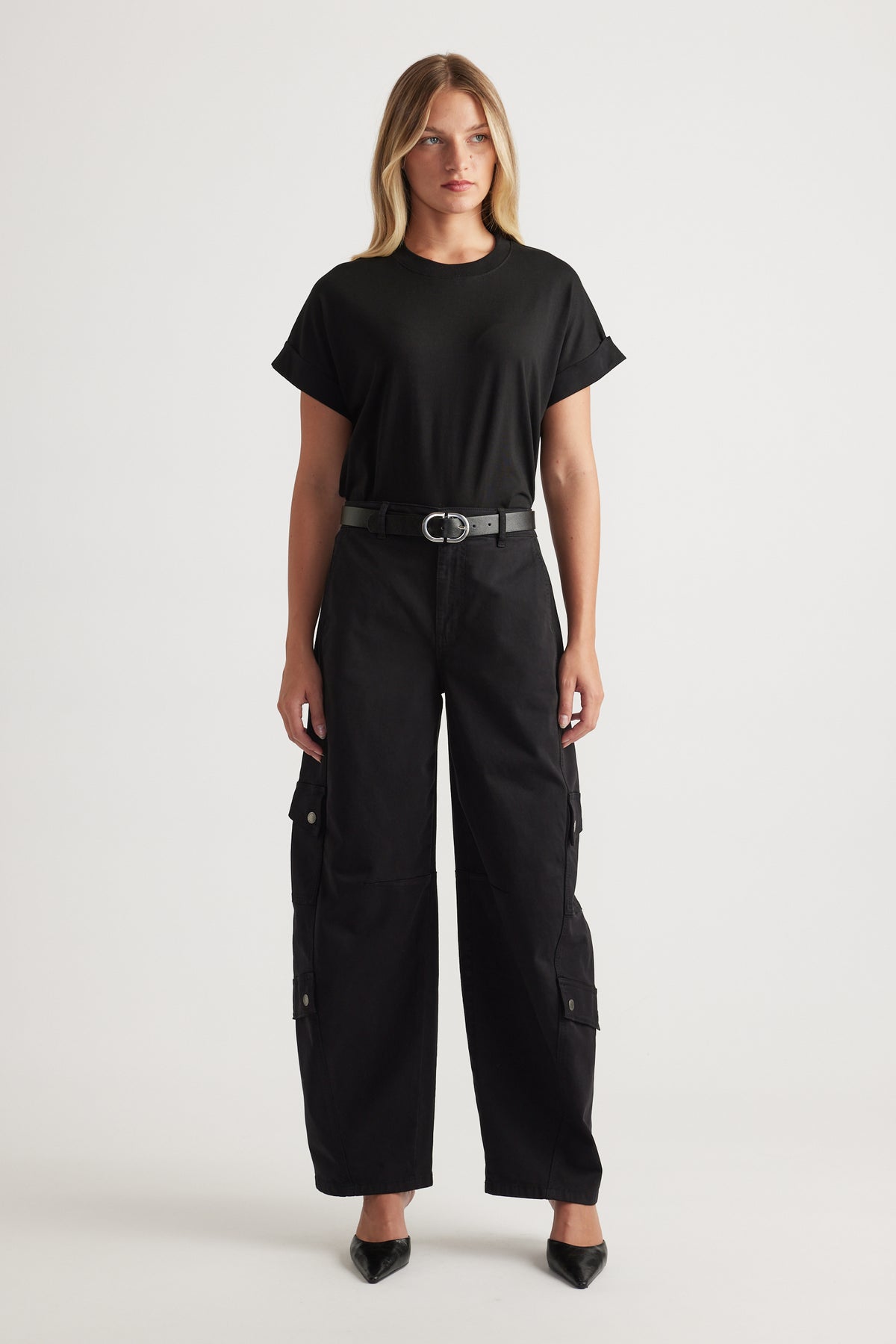 Woman wearing relaxed black cargo pants with a fitted black crew tee and a sleek belt for an effortless look
