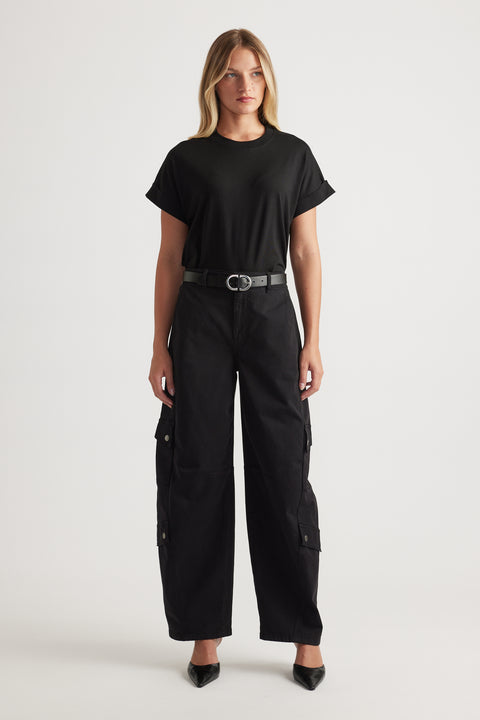 Woman wearing relaxed black cargo pants with a fitted black crew tee and a sleek belt for an effortless look