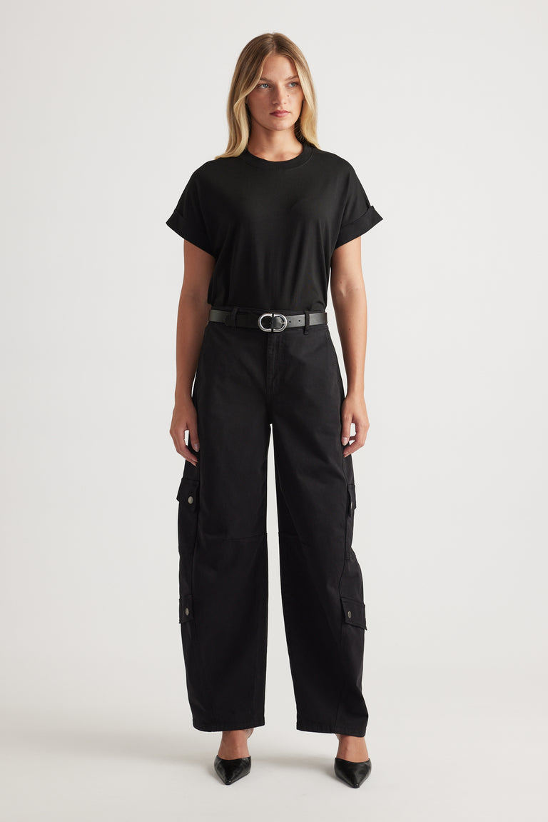 Woman wearing relaxed black cargo pants with a fitted black crew tee and a sleek belt for an effortless look