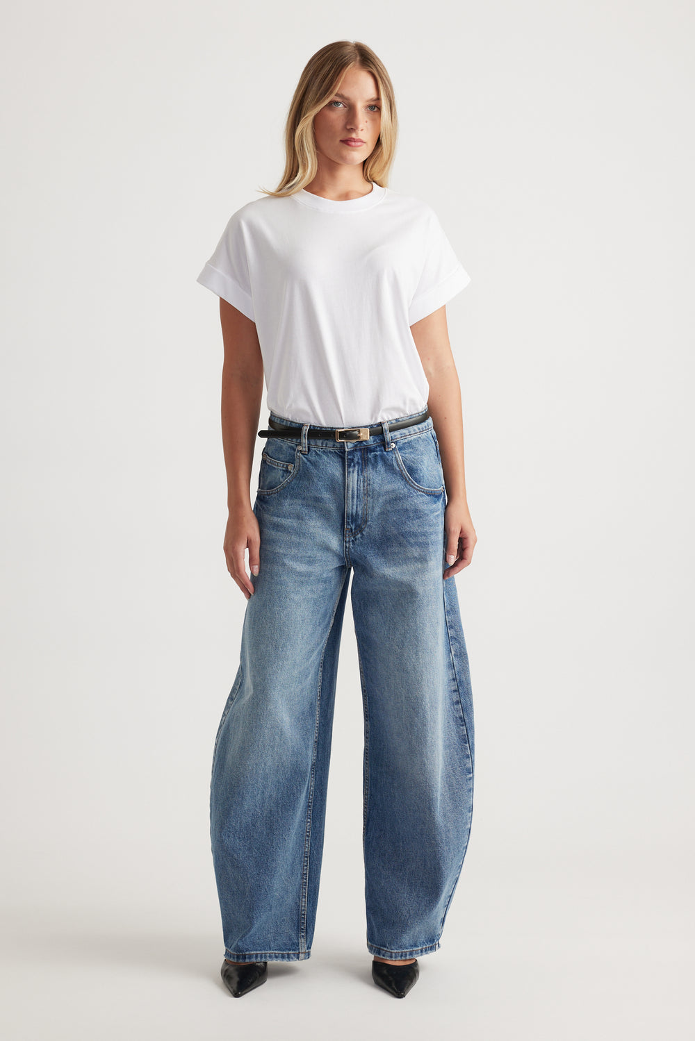Woman wearing a white crew neck tee with relaxed wide leg blue jeans