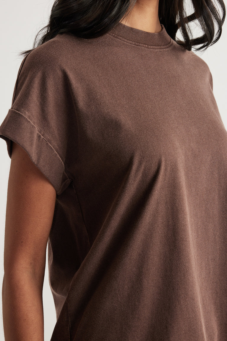 Woman wearing a brown crew neck tee with drop shoulders and rolled cuffs