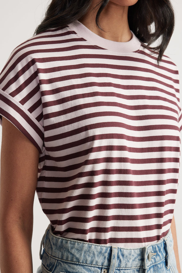 Close-up of a woman wearing a maroon and white striped rolled cuff tee paired with light wash denim jeans