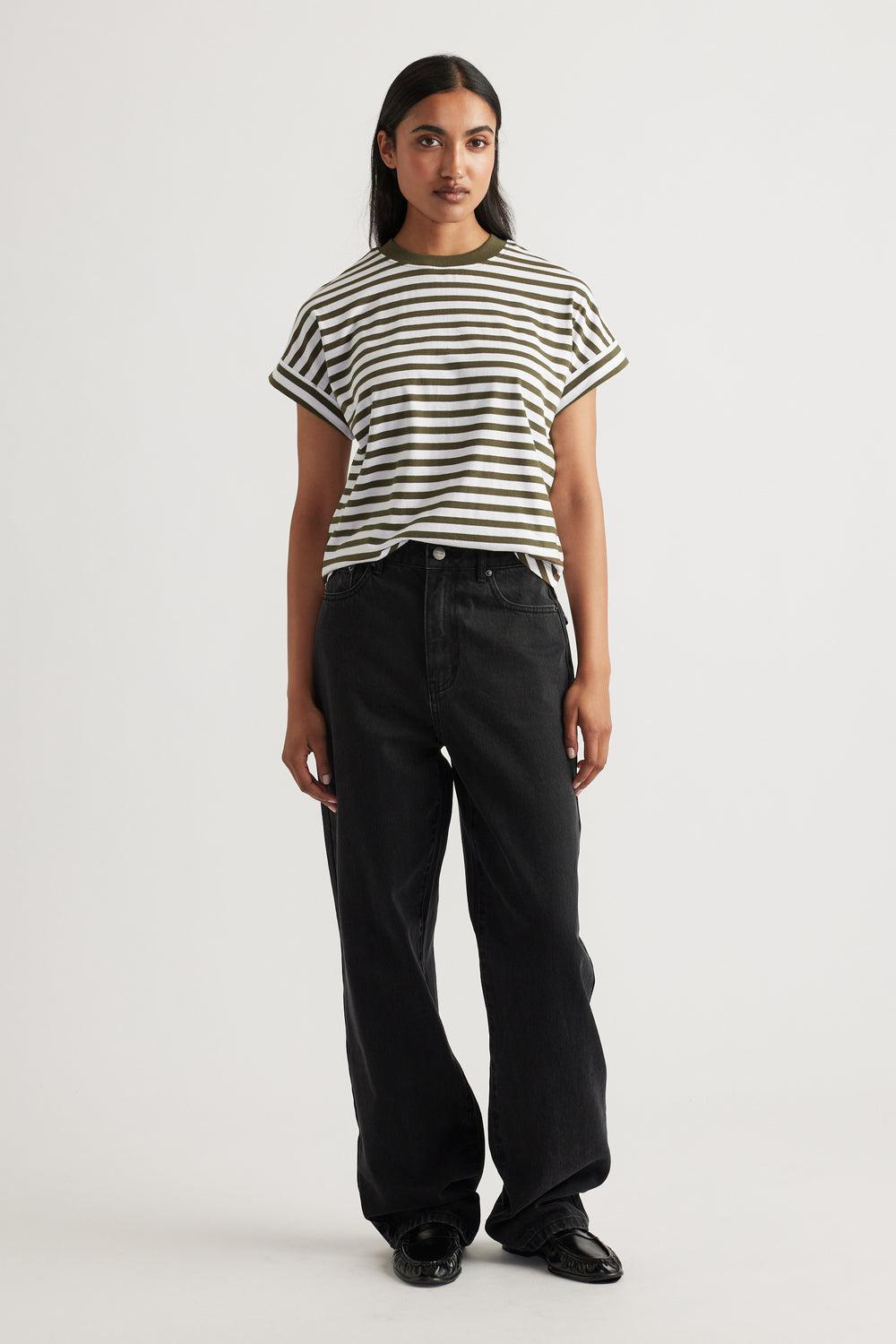 Woman wearing an olive and white striped Chloe Crew Tee with cuffed sleeves paired with loose black denim jeans