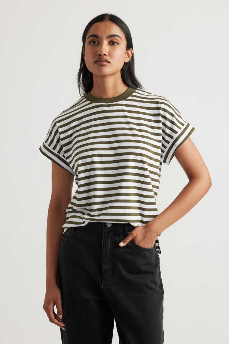 Woman wearing an olive and white striped Chloe Crew Tee with rolled sleeves paired with high-waisted black denim jeans