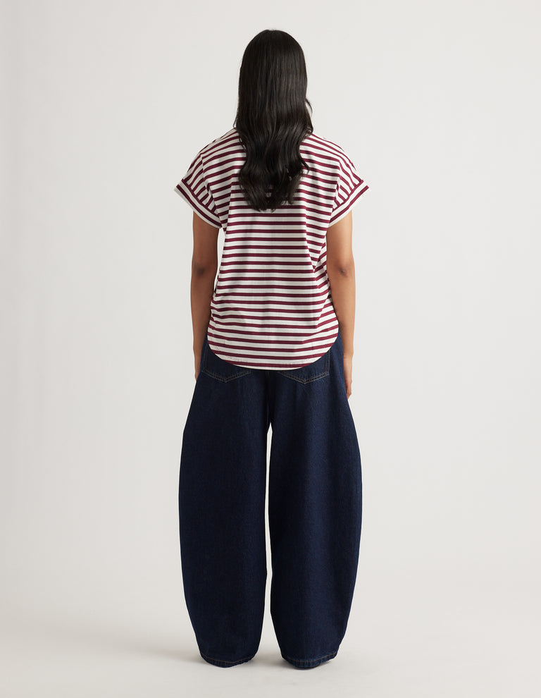 Woman wearing a relaxed fit striped tee with rolled sleeves paired with wide-leg dark denim jeans in a casual look