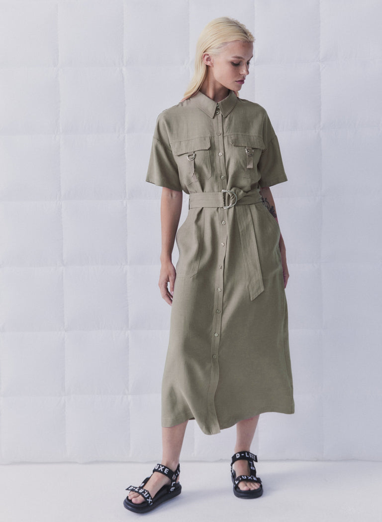 Woman wearing an olive collared midi dress with short sleeves, button front, cargo pockets and a D-ring belt