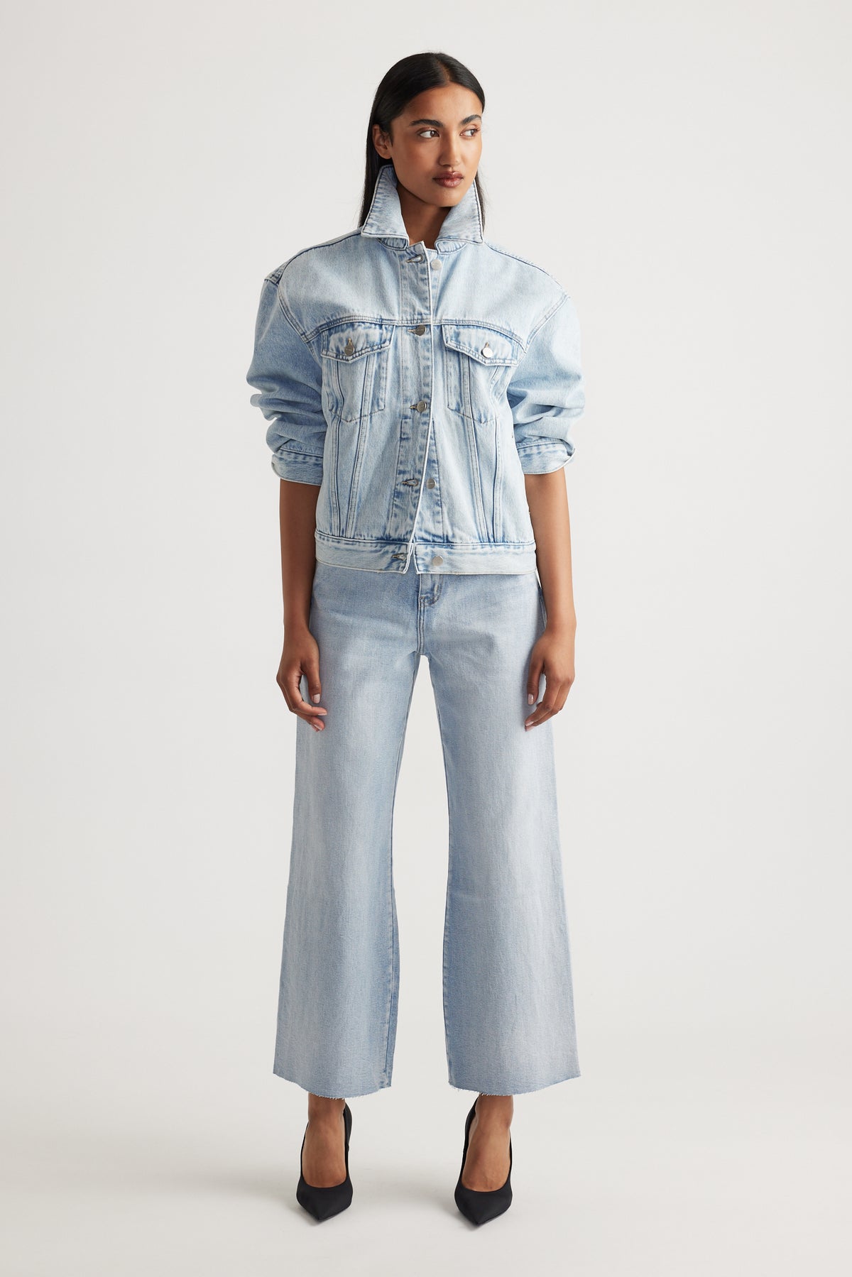 Woman wearing Tahni Wide Leg Jean in light denim styled with matching oversized denim jacket by Decjuba Australian brand