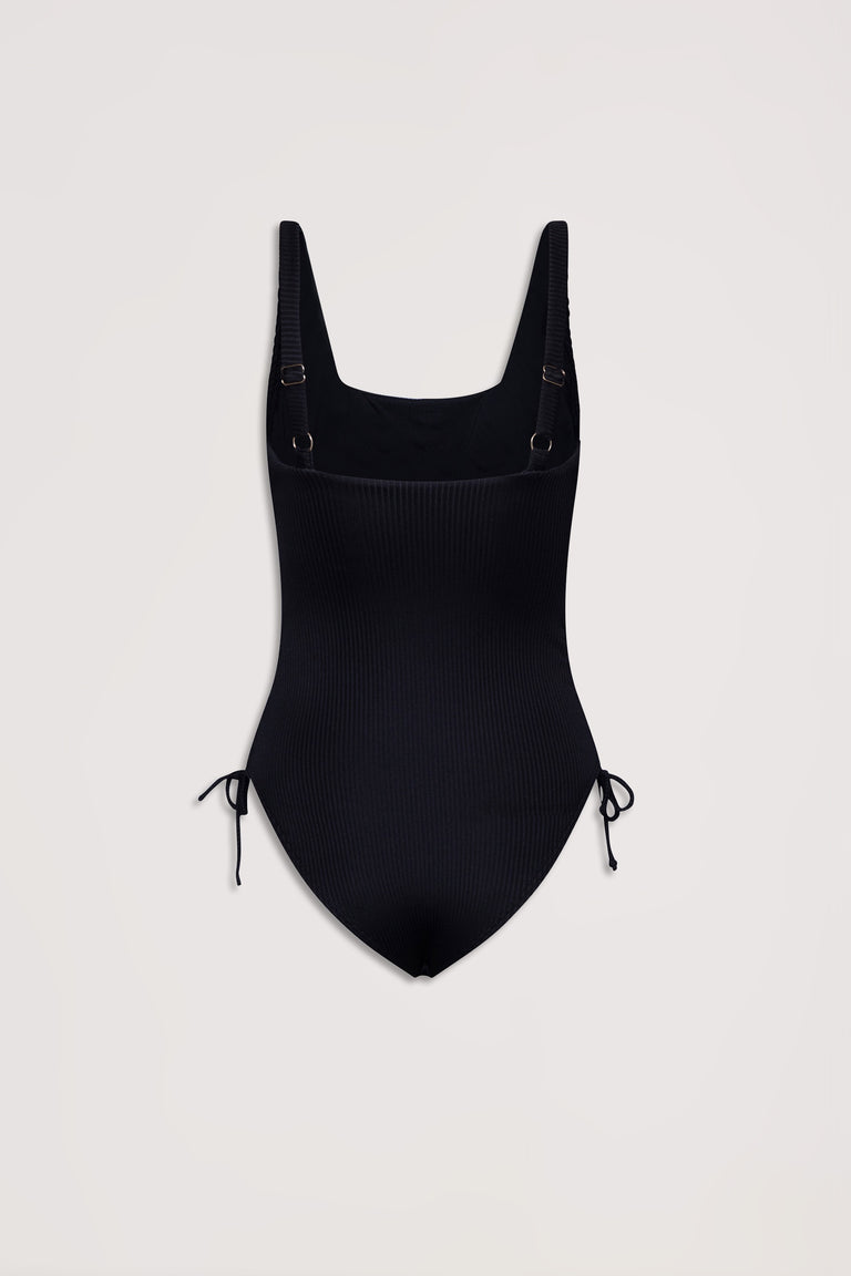 Black ribbed one-piece swimsuit with adjustable shoulder straps and side drawcord tie details on a plain background