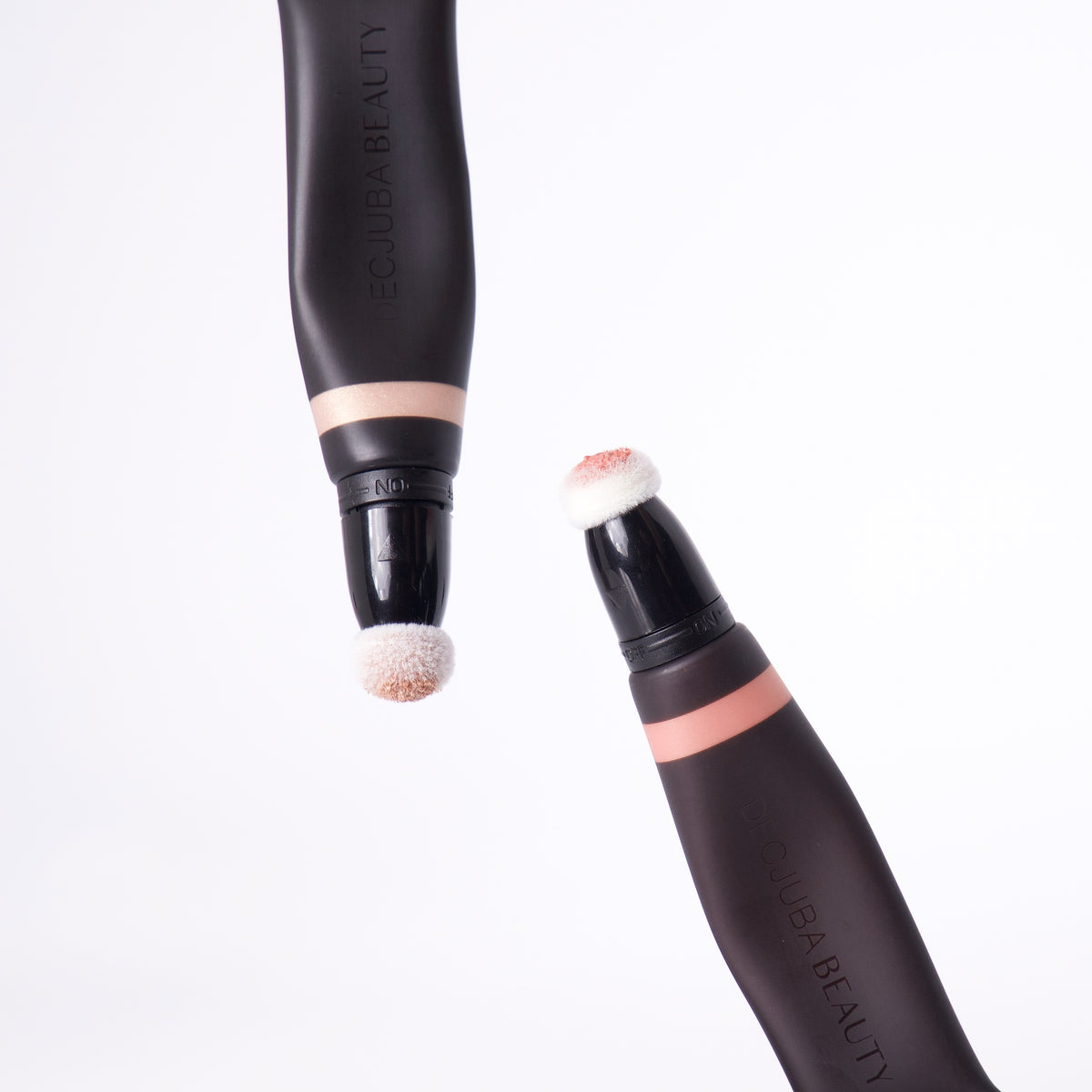 Two highlighting wands with soft sponge applicators in black and rose gold tones