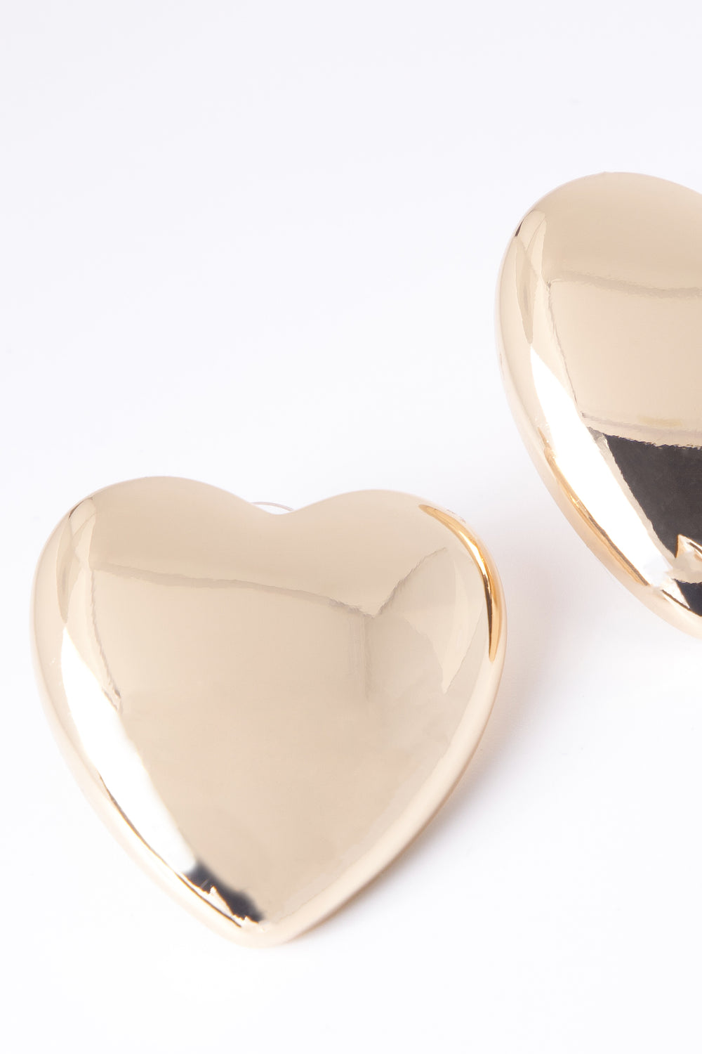 Oversized polished gold heart-shaped stud earring close-up
