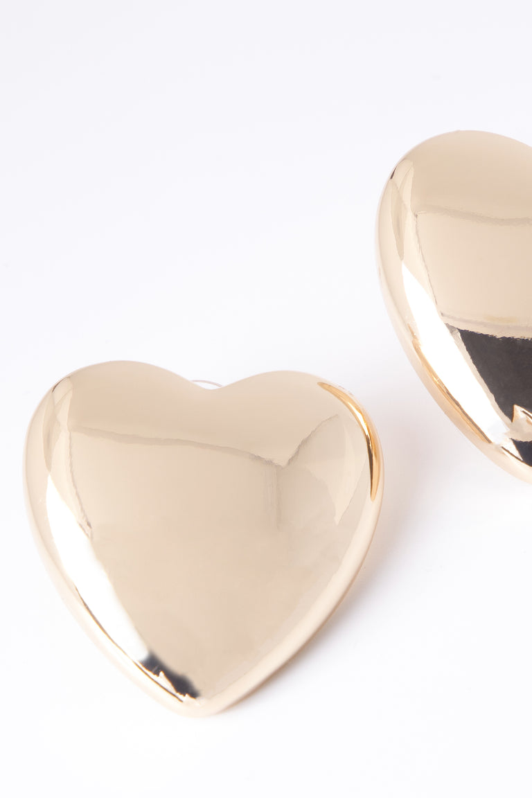 Oversized polished gold heart-shaped stud earring close-up