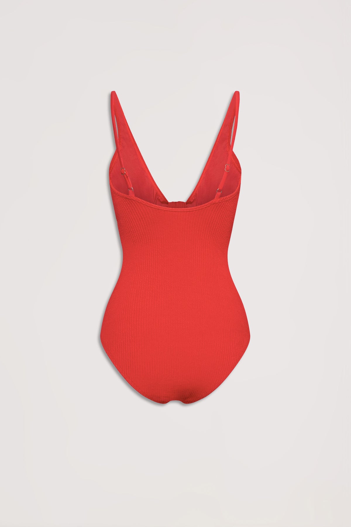 Red textured one-piece swimsuit with adjustable straps and a deep scoop back, laid flat on a neutral background