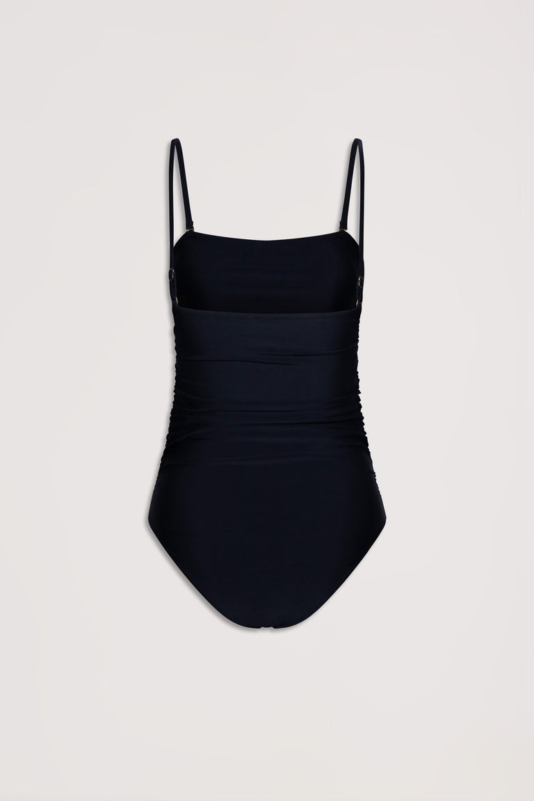 Black matte one-piece swimsuit with adjustable thin straps and subtle ruched detailing for a flattering fit