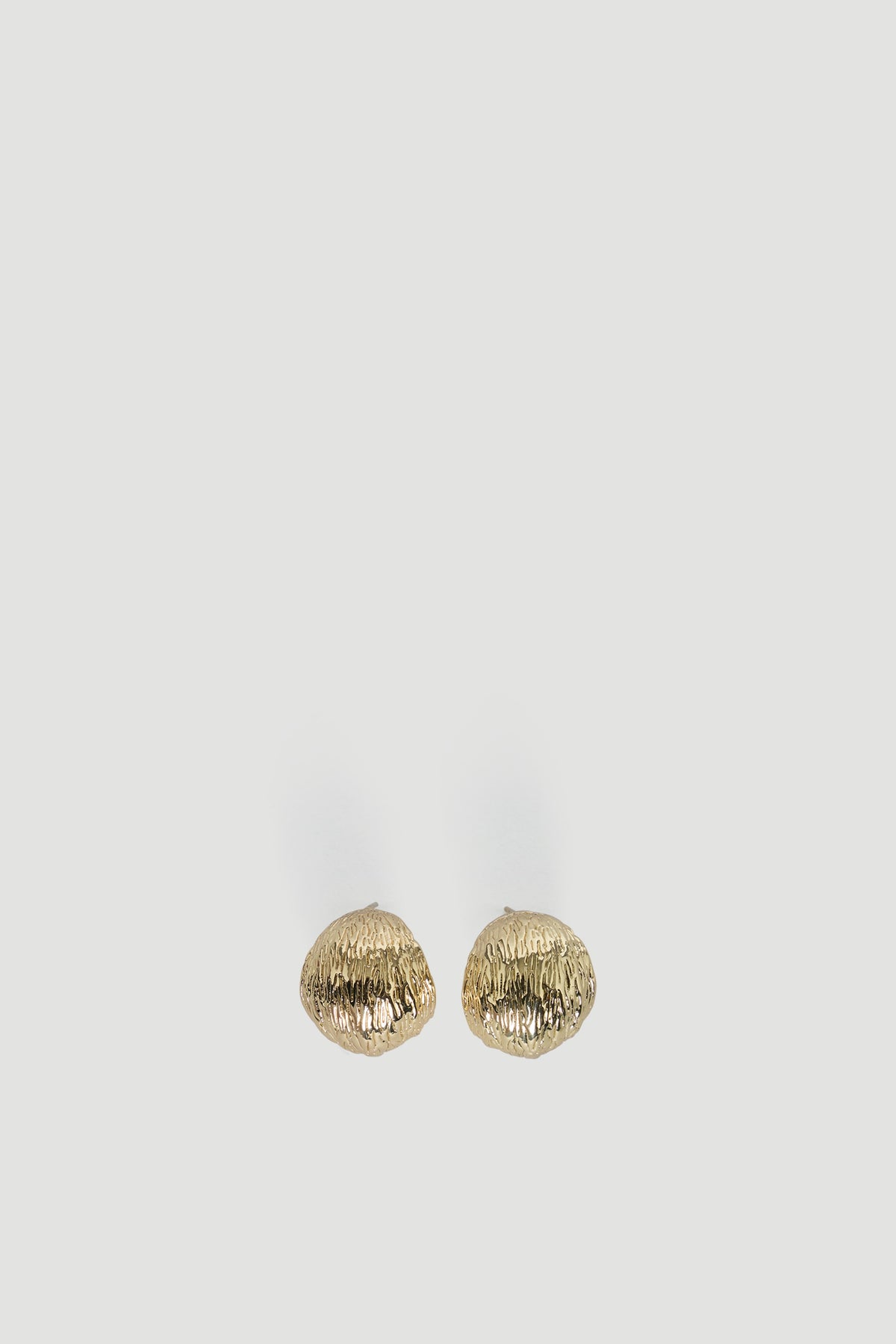 Pair of textured gold-tone chunky hoop earrings with an organic shape for a bold, modern accessory look.