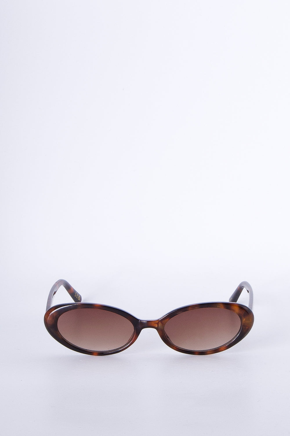 Oval tortoiseshell sunglasses with gradient brown lenses for a stylish, timeless accessory look.