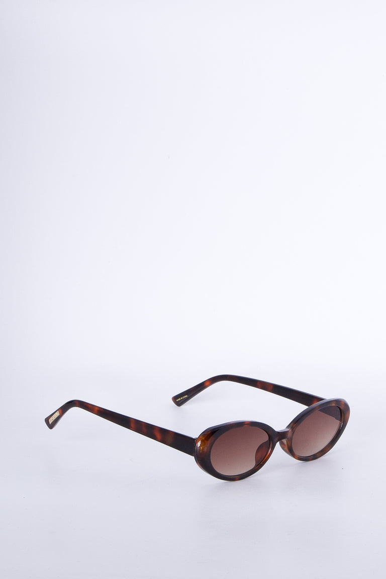Oval sunglasses with a brown tortoiseshell frame and tinted lenses for a refined, timeless accessory.