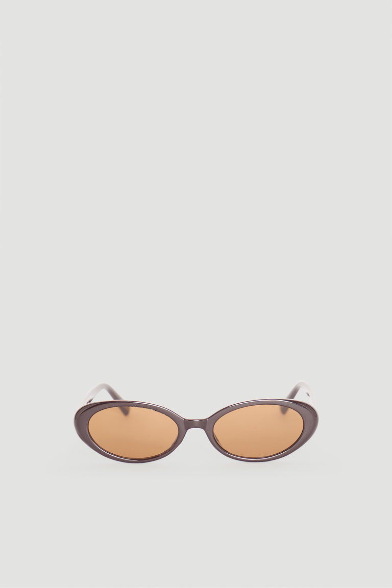 Sleek brown oval sunglasses with warm amber lenses offering a timeless, sophisticated accessory for everyday style.