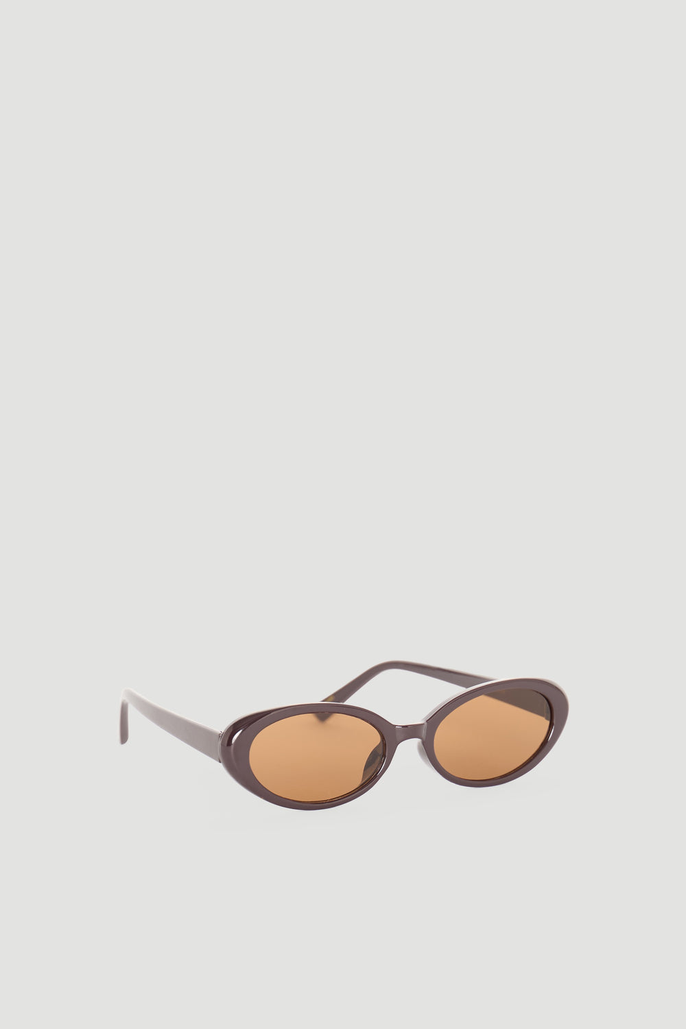 Sleek brown oval sunglasses with warm amber lenses offering a stylish, timeless accessory for everyday wear.