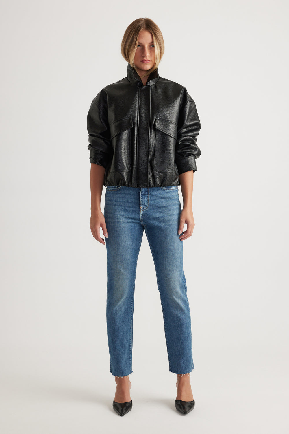 Front view of woman wearing Becky Straight Leg Jean in classic blue denim paired with black faux leather jacket by Decjuba