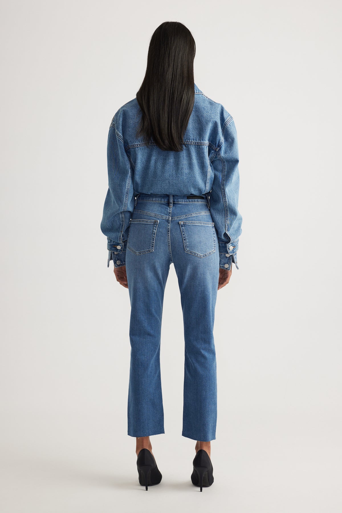 Rear view of model wearing Becky Straight Leg Jean in mid blue denim styled with matching denim jacket by Decjuba Australian brand
