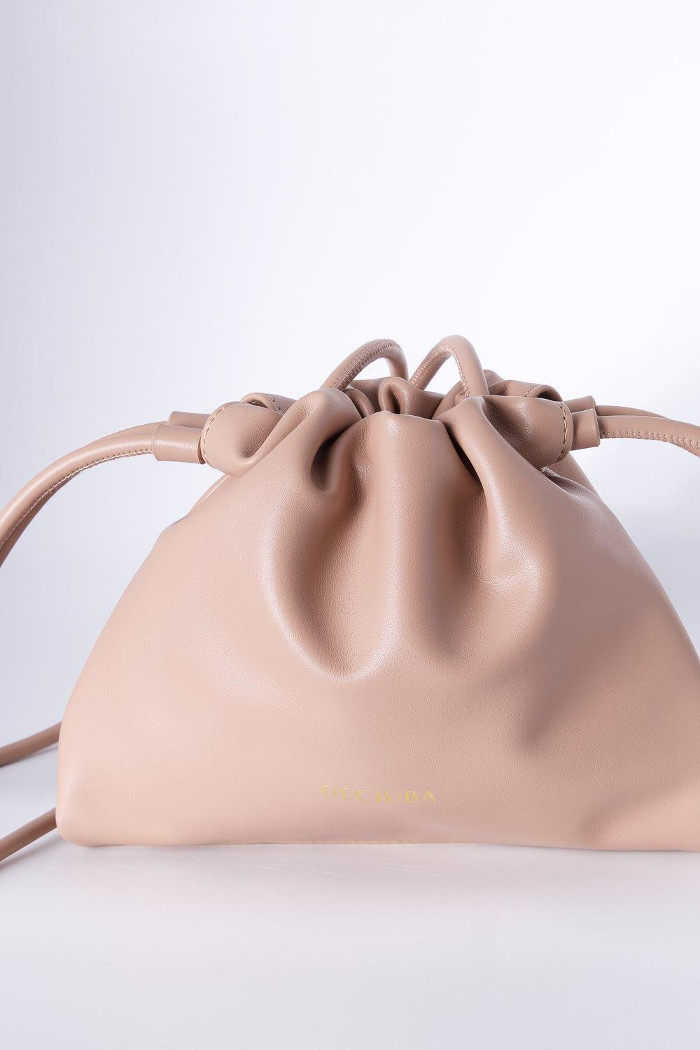 Blush pink drawstring sling bag with a thin strap and subtle front logo