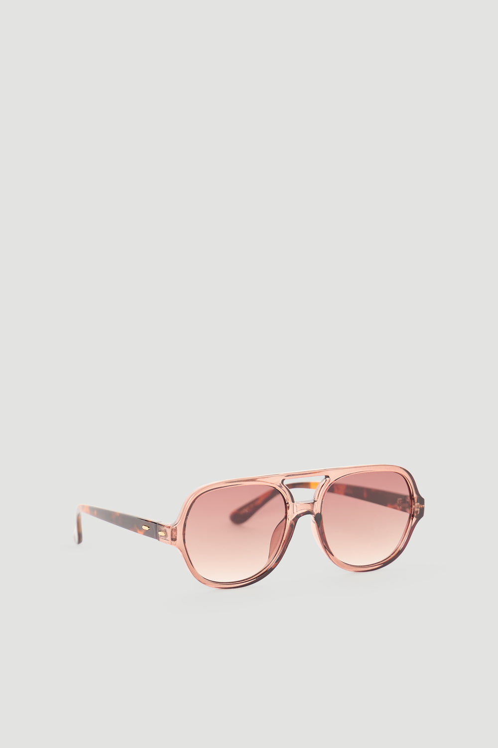 Light pink aviator sunglasses with gradient lenses and a translucent frame for a chic, modern accessory look.