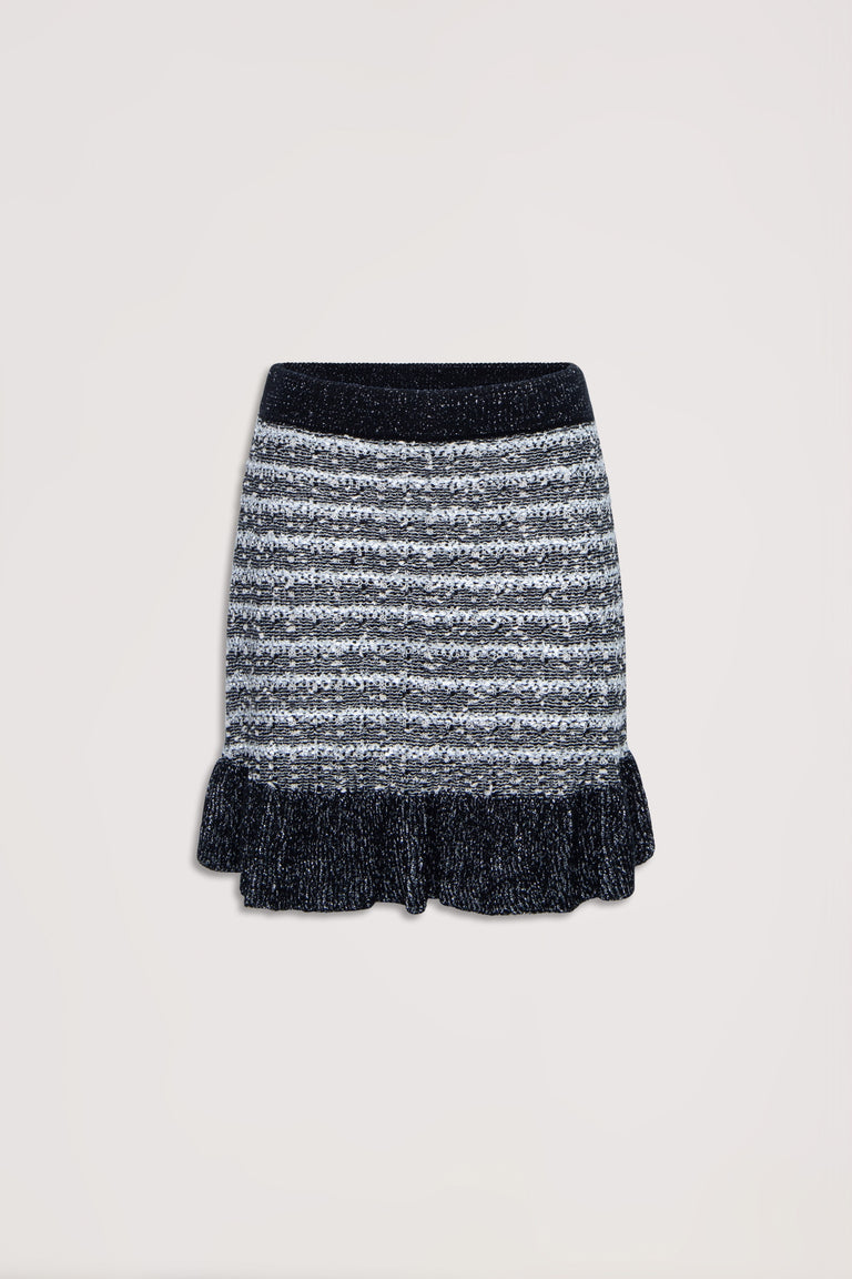 Black and white striped knit skirt with ruffled hem and a cozy textured waistband, flat lay on neutral background