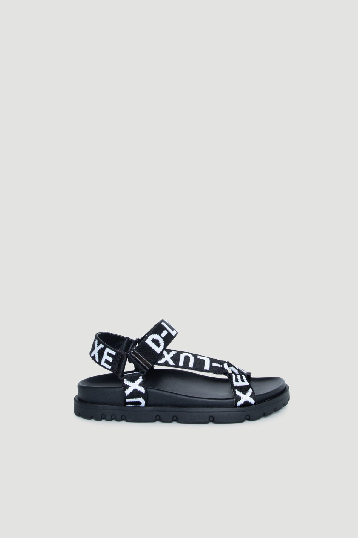 D-Luxe Desi Flat Sanda black webbed adjustable ankle strap with bold white logo straps portrait 1880x2820