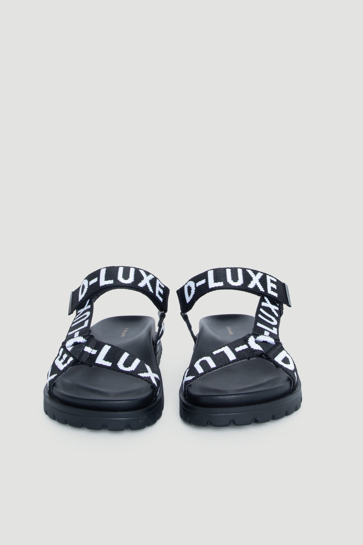 Front view of D-Luxe Desi Flat Sandal in gallery position 2 with adjustable ankle straps and bold branding