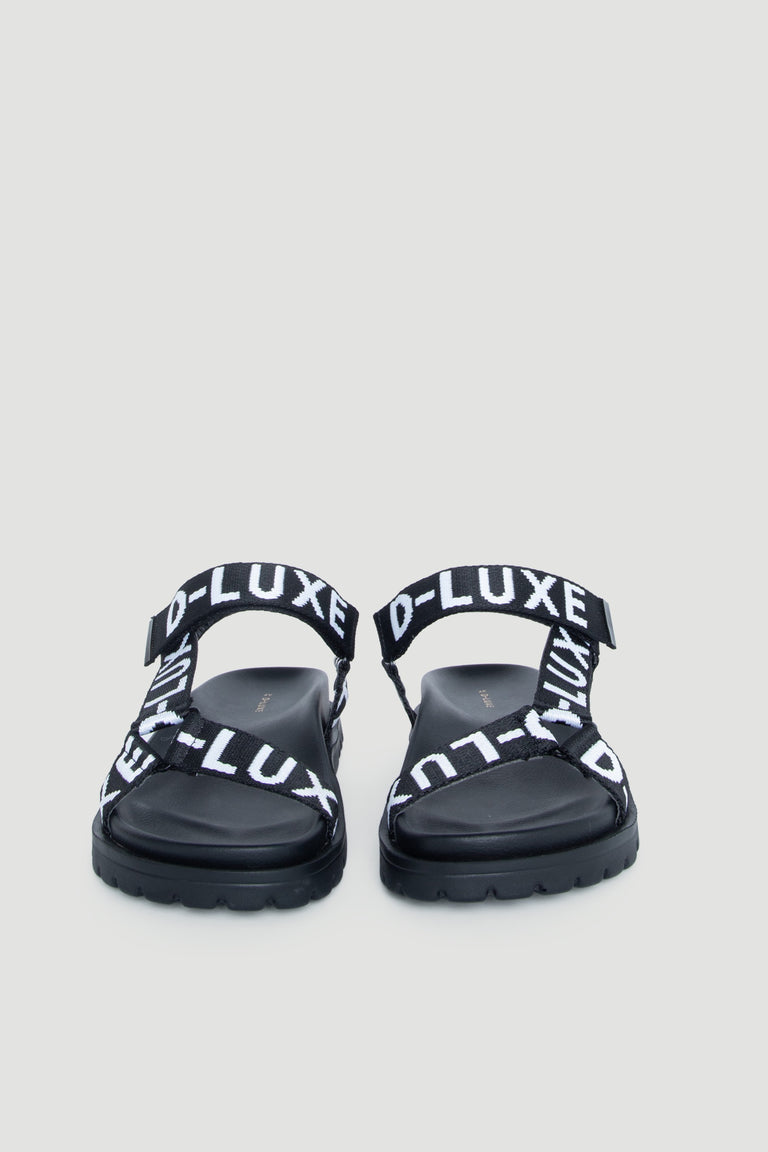 Front view of D-Luxe Desi Flat Sandal in gallery position 2 with adjustable ankle straps and bold branding