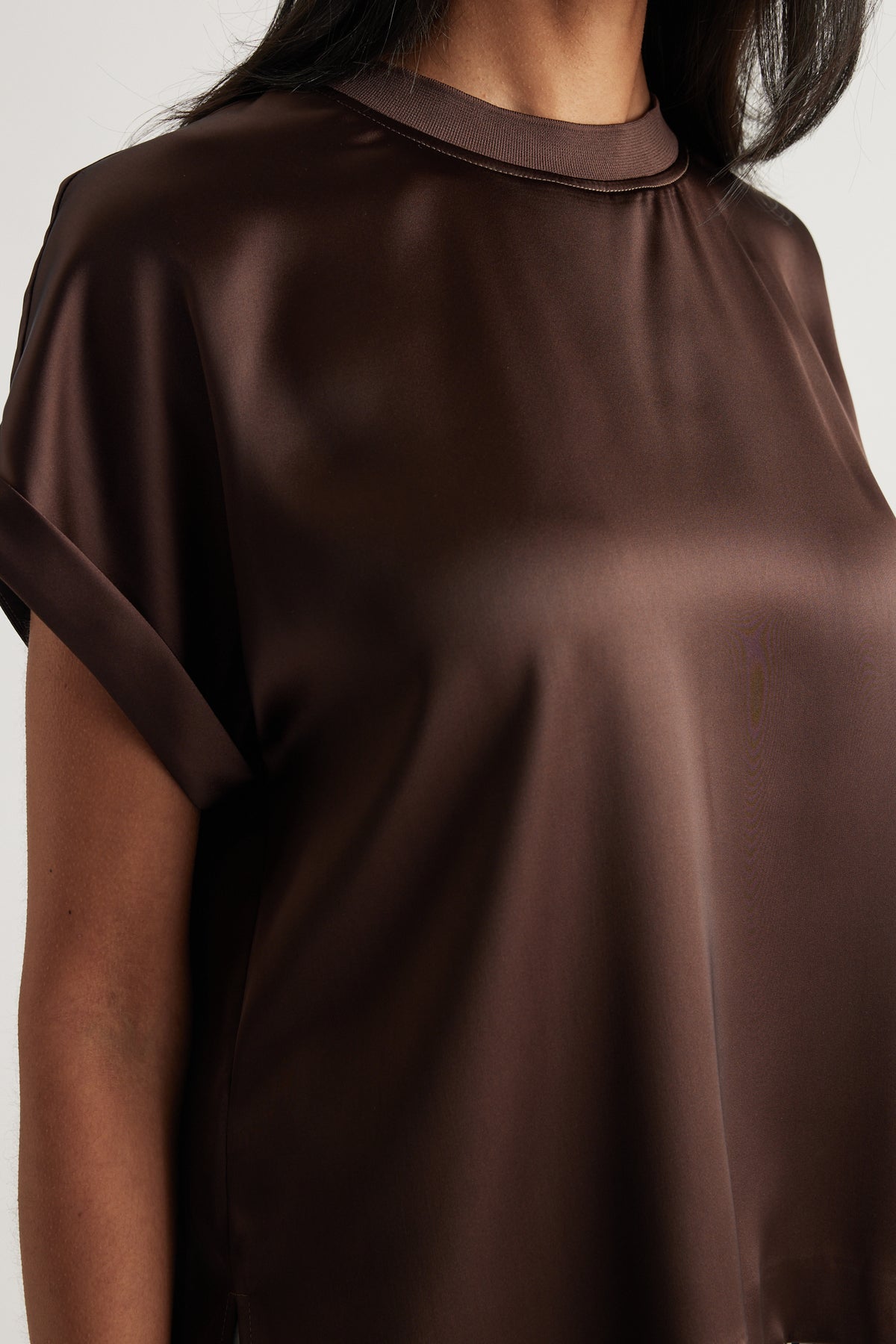 Woman wearing a dark brown satin finish crew neck tee with relaxed short sleeves