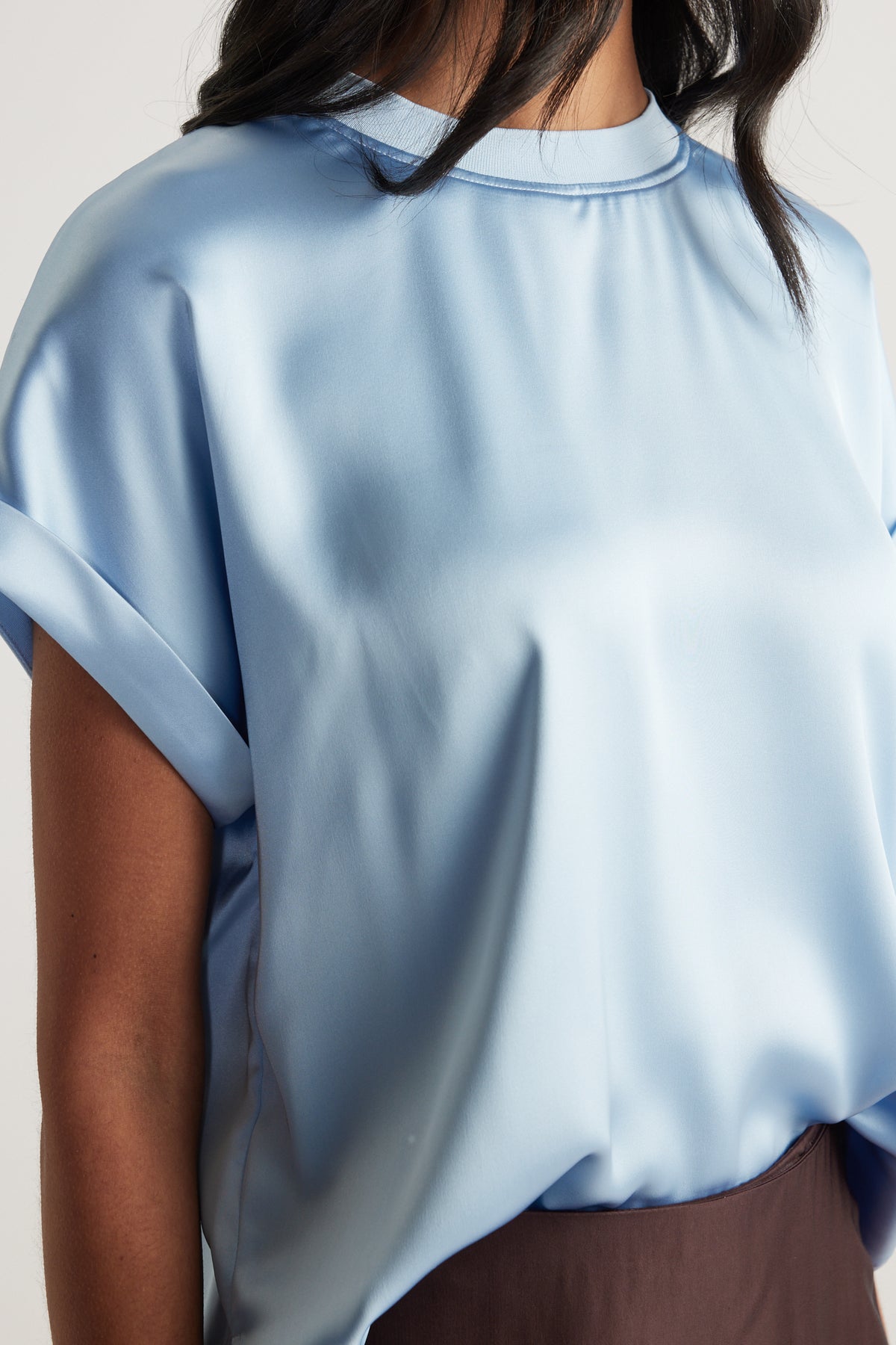 Woman wearing a light blue satin tee with a relaxed silhouette